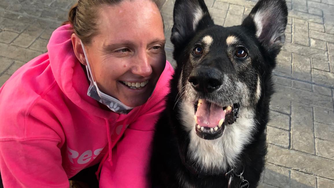 Smiling person next to Tanya the dog, who is also smiling