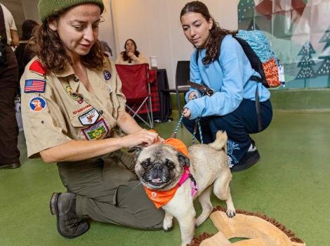 A couple adventure buddy program participants with a pug wearing a bandanna