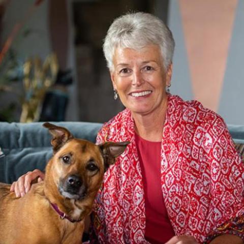 Denise "Dee" Clark sitting with small brown dog
