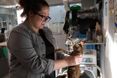 Jess Ewing holding Indy the kitten on a vibration plate