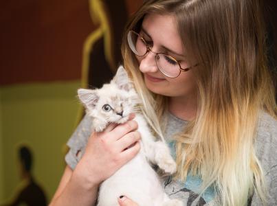 Smiling person holding a kitten