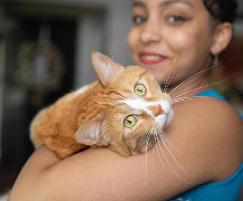 Smiling person holding a cat