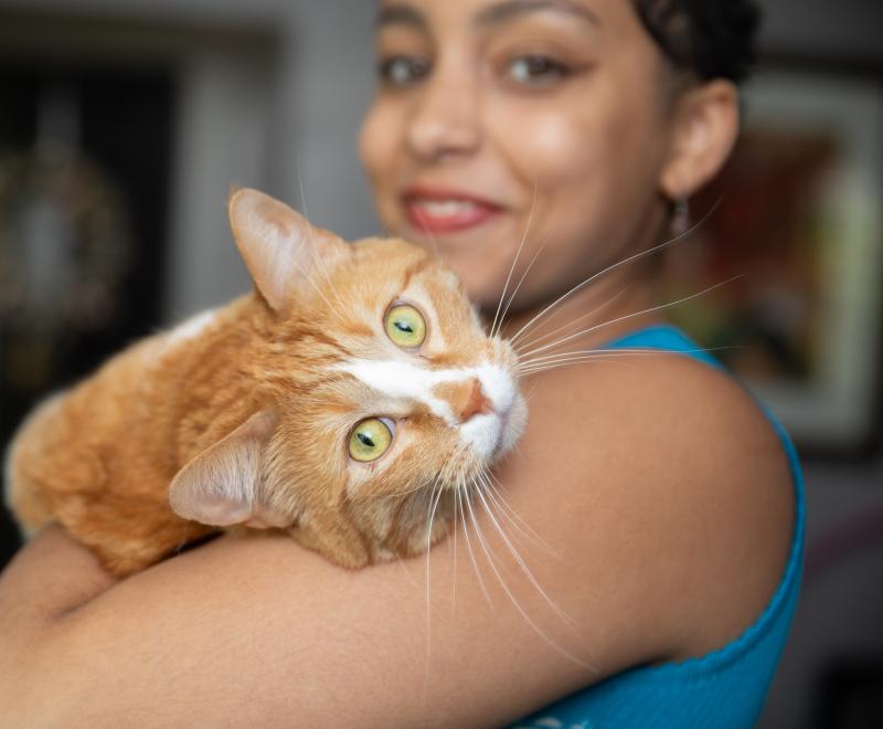 Smiling person holding a cat