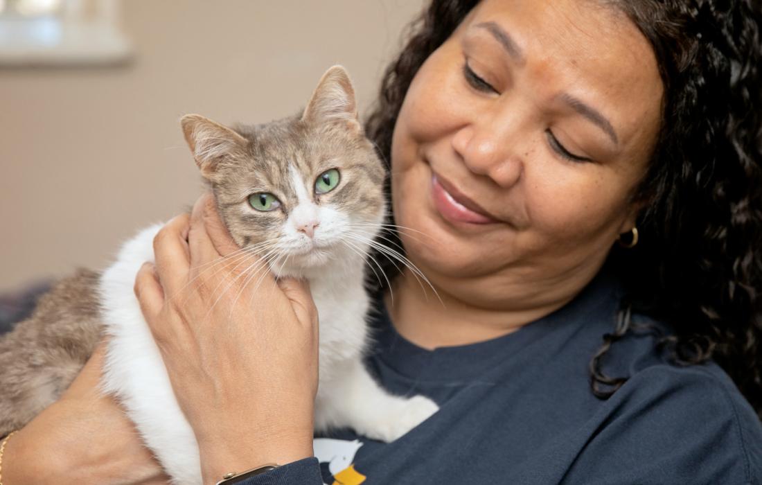 Person smiling and holding a cat